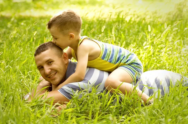 Pai e filho brincando no campo verde — Fotografia de Stock