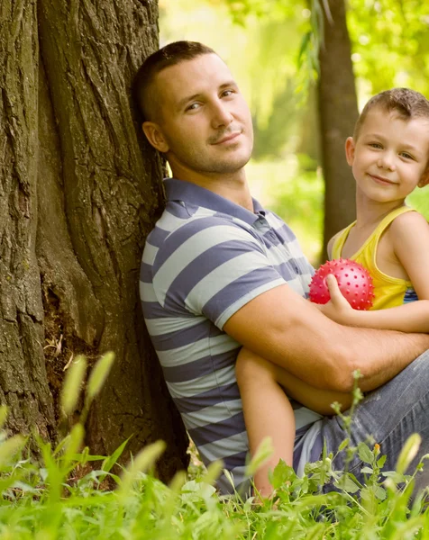 Pai e filho brincando no campo verde — Fotografia de Stock