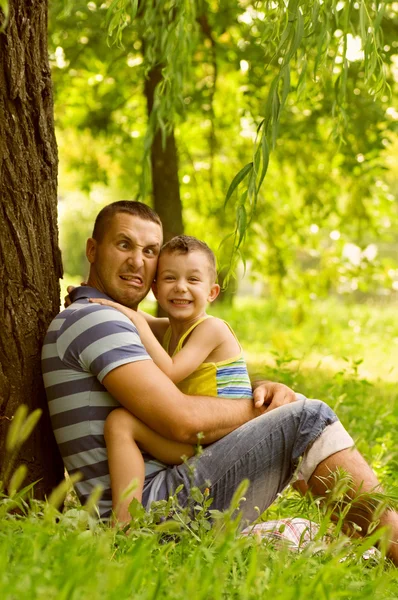 Pai e filho brincando no campo verde — Fotografia de Stock