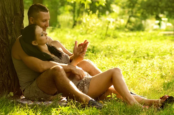 Young couple laying on park lawn — Stock Photo, Image