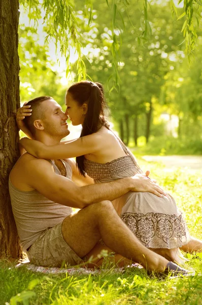 Pareja joven tendida en el césped del parque — Foto de Stock