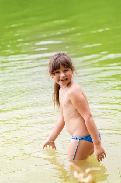 Kleines süßes Mädchen spielt im Fluss — Stockfoto