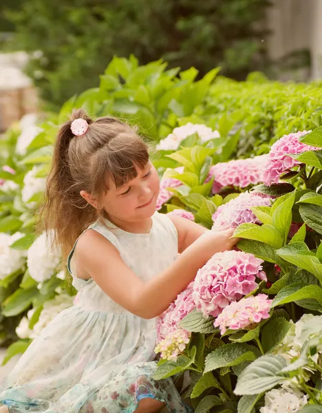 Glad vacker flicka luktar blommor — Stockfoto