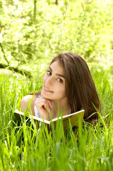 Belle femme au jardin de printemps lisant un livre — Photo