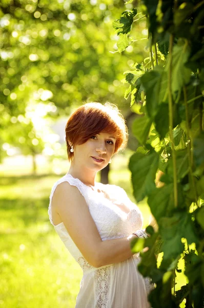 Beautiful pregnant woman in green garden — Stock Photo, Image