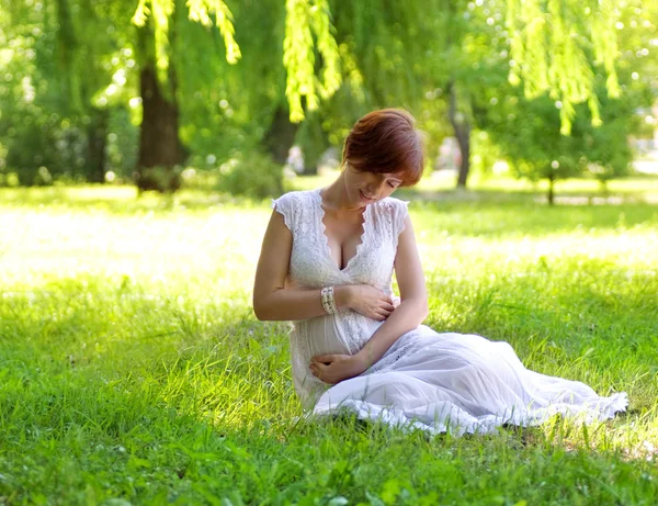 Mulher grávida bonita no jardim verde — Fotografia de Stock