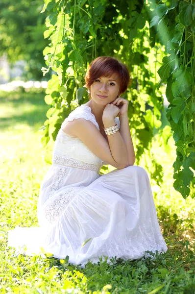 Mooie vrouw in groene tuin — Stockfoto