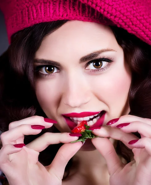 Junge Frau mit Erdbeere in roter Baskenmütze — Stockfoto