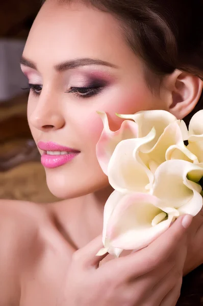 Beauty face of the young woman with flowers Stock Image