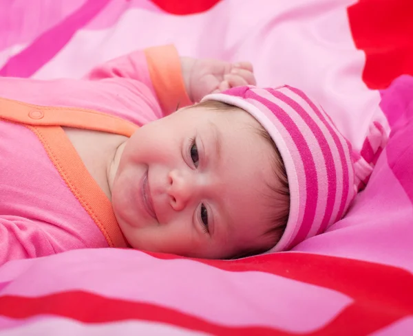 Mooie babymeisje op roze achtergrond — Stockfoto