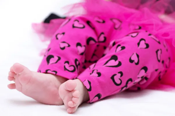 Newborn baby girl feet in pink clothes — Stock Photo, Image