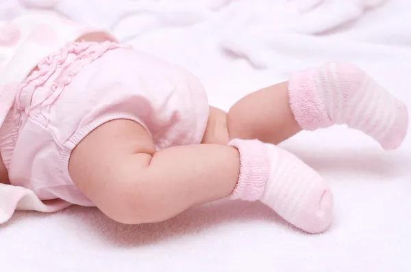 Bebé recién nacido pies de niña en calcetines rosados —  Fotos de Stock