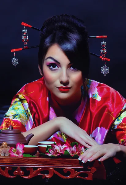 Женщина в азиатском костюме устраивает чайную церемонию — стоковое фото