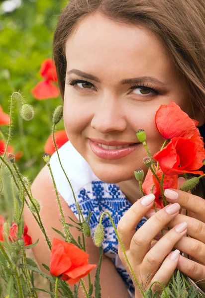 Vacker kvinna med röda vårblommor i en trädgård — Stockfoto