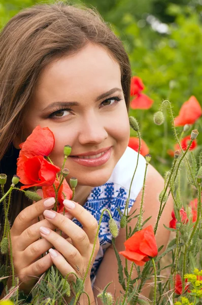 Vacker kvinna med röda vårblommor i en trädgård — Stockfoto