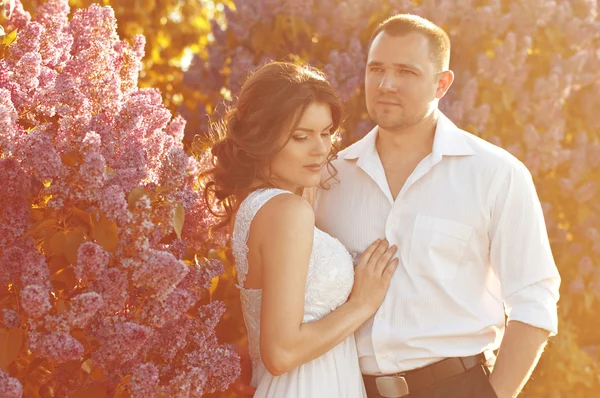 Recién casados cerca de las lilas — Foto de Stock