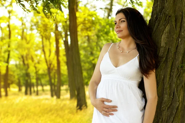 Hermosa embarazada en el jardín — Foto de Stock