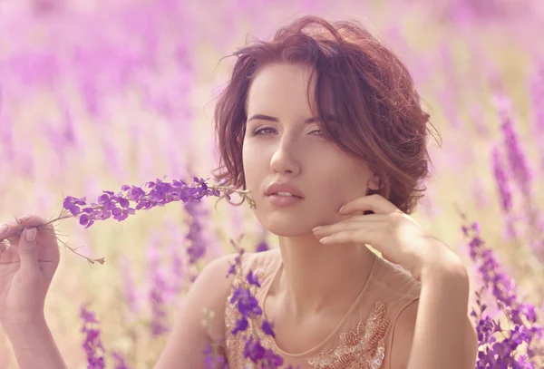 Vrouw met violette bloemen — Stockfoto