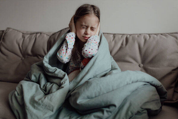 Stop war. Pray for Ukraine. we stand with Ukraine. Ukrainian frightened child under a blanket. The girl is afraid of the sounds of air raids and explosions. Poor child feeling sorrow and sadness, bad luck and grief problems. 