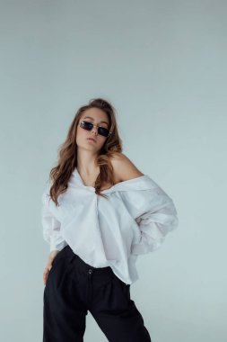 Işıklı arka planda güzel bir kız model. Kadın vücudu ve tarz kavramı. Reklam ya da kıyafet satışı tasarımı. Metin boşluğu