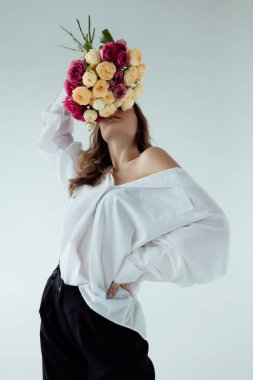 Bir buket gülü olan güzel bir manken kız. Aydınlık arka planda Spring Lady. Kadın vücudu ve tarz kavramı. Reklam ya da kıyafet satışı tasarımı. Metin boşluğu