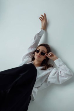 Işıklı arka planda güzel bir kız model. Kadın vücudu ve tarz kavramı. Reklam ya da kıyafet satışı tasarımı. Metin boşluğu