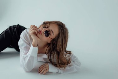 Işıklı arka planda güzel bir kız model. Kadın vücudu ve tarz kavramı. Reklam ya da kıyafet satışı tasarımı. Metin boşluğu