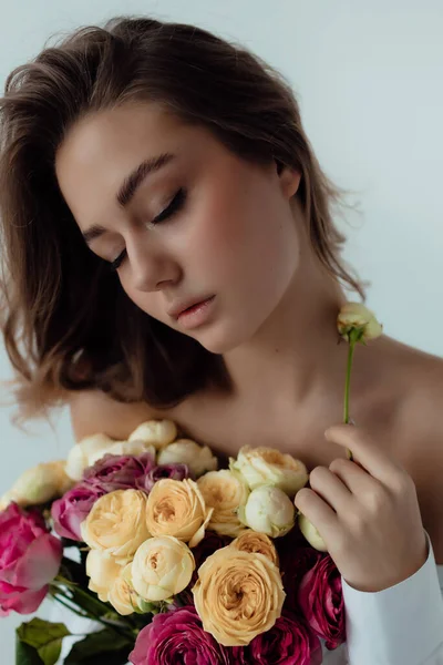 バラの花束と美しい女の子のモデル 光の背景に春の女性 女性の身体とスタイルの概念 広告や服の販売デザイン テキストの空間 — ストック写真