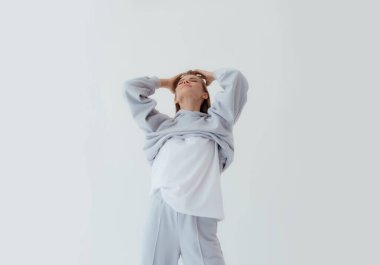 Eşofmanlı Ukraynalı genç kadın arka planda ışık taklidi yapıyor. Kadın vücudu ve tarz kavramı. Reklam ya da kıyafet satışı tasarımı. Tasarım için modelleme, kıyafet mağazası satışı. Duygusal kadını kapat.