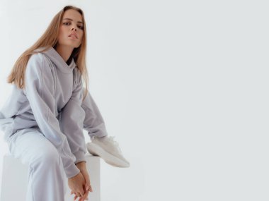 Eşofmanlı Ukraynalı genç kadın arka planda ışık taklidi yapıyor. Kadın vücudu ve tarz kavramı. Reklam ya da kıyafet satışı tasarımı. Tasarım için modelleme, kıyafet mağazası satışı. Duygusal kadını kapat.