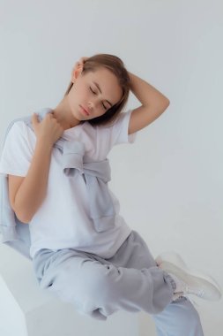 Eşofmanlı Ukraynalı genç kadın arka planda ışık taklidi yapıyor. Kadın vücudu ve tarz kavramı. Reklam ya da kıyafet satışı tasarımı. Tasarım için modelleme, kıyafet mağazası satışı. Duygusal kadını kapat.