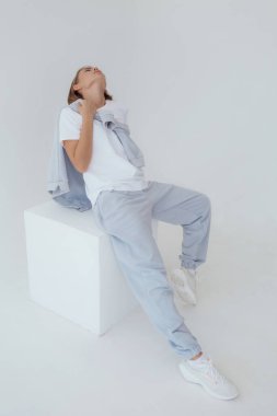 Eşofmanlı Ukraynalı genç kadın arka planda ışık taklidi yapıyor. Kadın vücudu ve tarz kavramı. Reklam ya da kıyafet satışı tasarımı. Tasarım için modelleme, kıyafet mağazası satışı. Duygusal kadını kapat.