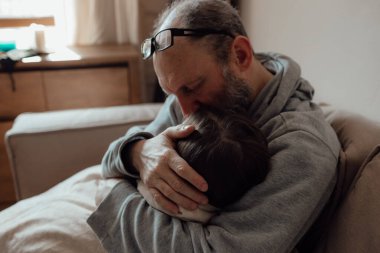 Savaşı durdurun. Ukraynalı endişeli orta yaşlı beyaz adam korkmuş küçük torunu destekliyor. Mutsuz, olgun büyükbaba ve küçük kız evde. Ukrayna için dua et. Ukrayna 'nın yanındayız..