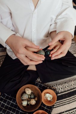 Mutlu aile paskalya yumurtalarını içeride hazırlıyor. Anne ve çocuk evde birlikte mutlu Paskalya tatili kutluyorlar. Şükran Günü gelenekleri ve çocukluk birlikteliği kavramı. Tatil gelenekleri. Kutlama ve sevinç konsepti.