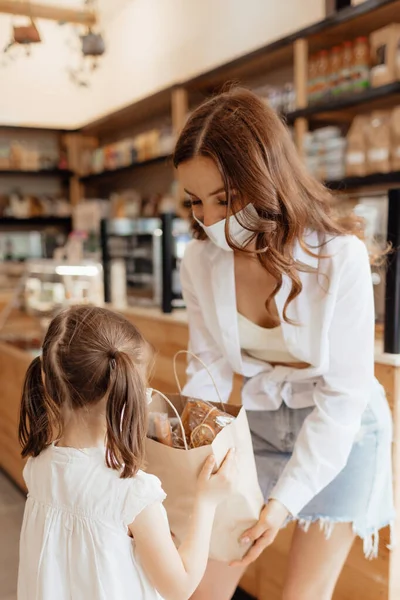 Young Mother Daughter Medical Masks Shopping Paper Bag Counter Cafe — Stock Photo, Image