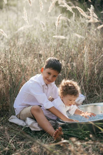 Happy Two Brothers Playing Water Basin Wheat Summer Field Adventure — стоковое фото