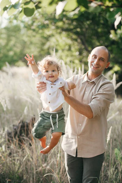 快乐的年轻人带着孩子在麦田里避暑 快乐的父亲 远足和人的概念 快乐的家庭步行 — 图库照片