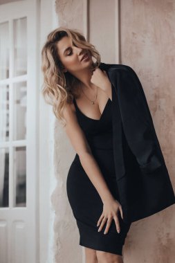 Stüdyoda açık bir arka planda poz veren güzel sarışın kız. Kadın vücudu ve tarz kavramı. Reklam ya da kıyafet satışı tasarımı.