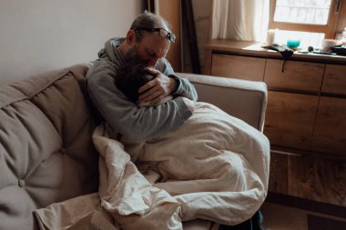 Ukraynalı endişeli orta yaşlı beyaz adam korkmuş küçük torunu destekliyor. Mutsuz, olgun büyükbaba ve küçük kız evde. Stres ve korku kavramı
