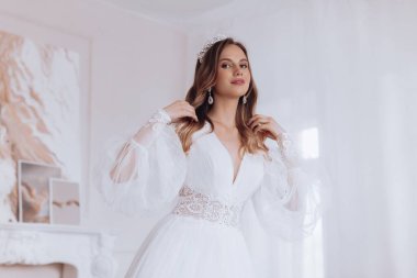 Havalı gelinlik içindeki güzel genç gelinin portresi. Hassas bir kadın portresi. Düğün makyajı. Doğal güzellik..