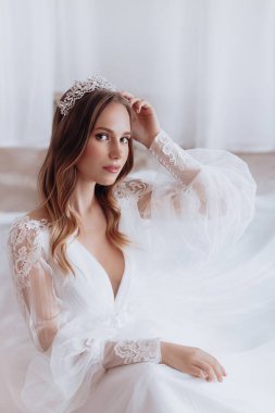 Havalı gelinlik içindeki güzel genç gelinin portresi. Hassas bir kadın portresi. Düğün makyajı. Doğal güzellik..