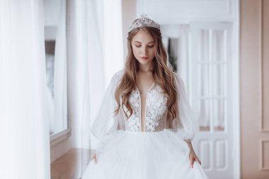 Havalı gelinlik içindeki güzel genç gelinin portresi. Hassas bir kadın portresi. Düğün makyajı. Doğal güzellik..