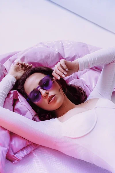 Ukrainian young girl in sunglasses and white bodysuit and jacket on light background. Female body and style concept. Advertisement or clothes sale design.
