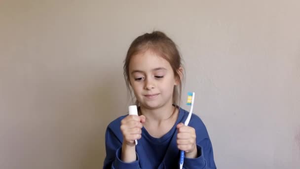 かわいい女の子はバスルームで彼女の歯を磨く 女の子の体重歯ブラシや歯磨き粉でダンスを食べた カメラを見ると — ストック動画