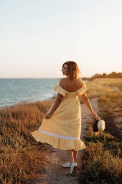 Kumsalda esintiyi hisseden mutlu olgun bir kadın. Sahilde orta yaşlı güzel bir kadın. Orta yaşlı kadın kendini iyi hissediyor ve denizde özgürlüğün tadını çıkarıyor..