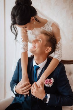 Beautiful young couple, the bride and groom. Luxurious light interior. Wedding day concept