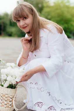 Mid lady feeling good and enjoying freedom at garden, copy space. Beautiful elderly woman in a light clothes. Elderly lifestyle at home concept. Advertisement or clothes sale design. Mock up for design, clothes shop sale.