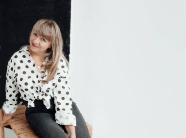 Beyaz arka planda beyaz elbiseli, mesajlaşmak için yeri olan yaşlı ve güzel bir kadın. Ev konseptinde yaşlı yaşam tarzı. Reklam ya da kıyafet satışı tasarımı. Kıyafet mağazası satışı için hazırlan..