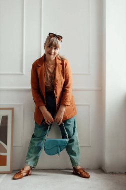 Beyaz arka planda beyaz elbiseli, mesajlaşmak için yeri olan yaşlı ve güzel bir kadın. Üst düzey kadın portresi. Reklam ya da kıyafet satışı tasarımı. Tasarım için modelleme, kıyafet mağazası satışı..