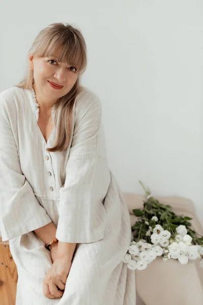 Hermosa Anciana Con Flores Que Lleva Ropa Ligera Sobre Fondo —  Fotos de Stock